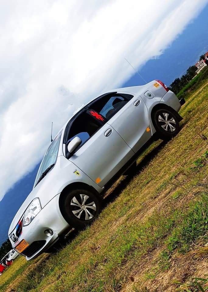 Toyota Etios silver sedan outstation taxi in green field